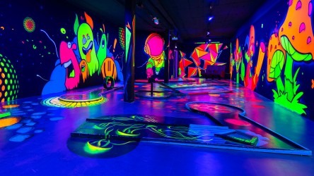 Eine Halle im Schwarzlicht Semester Münster, die Wände voll mit Zeichnungen in Neonfarbe.