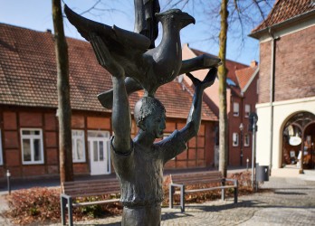Eine Statue vor einem Fachwerkgebäude in Drensteinfurt.