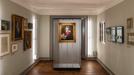 Ein Raum mit verschiedenen Abbildungen Beethovens an den Wänden. In der Raummitte wird ein weiteres Bild in einer Installation präsentiert.