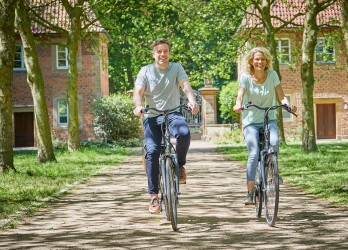 Ein Mann und eine Frau fahren mit dem Fahrrad durch den Bentlager Dreiklang.